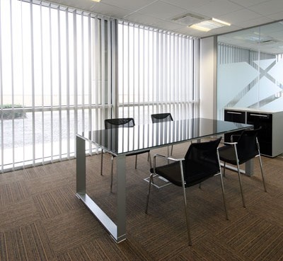 Bright conference room office space with white vertical blinds