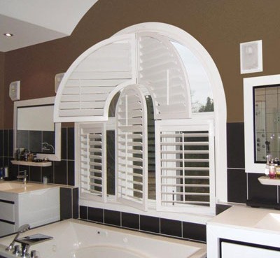 Bright modern bathroom with uniquely shaped white wood shutters