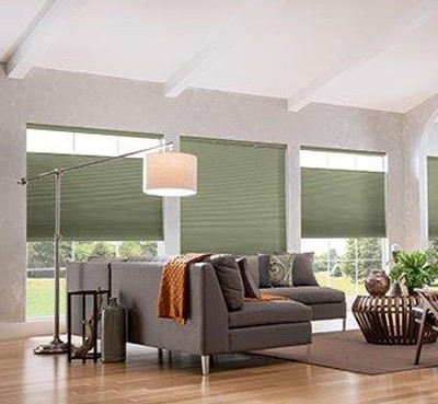 bright modern living room with light grey couch, pastel green window coverings