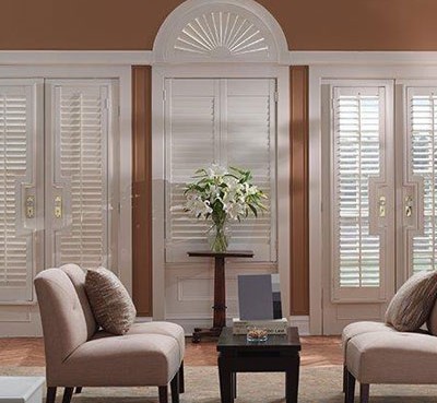bright modern living room with soft couch and white window shutters