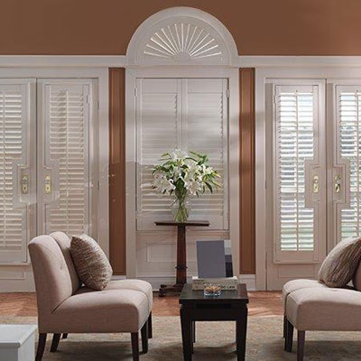 bright modern living room with soft couch and white window shutters