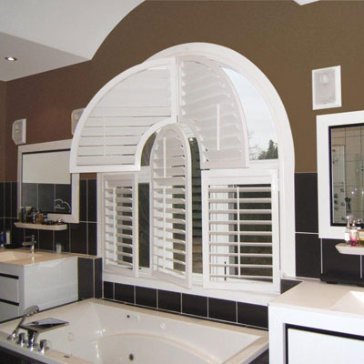 Bright modern bathroom with uniquely shaped white wood shutters