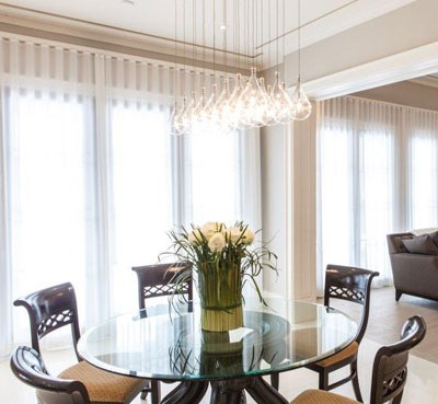 Elegant modern dining room with white blinds and flowers decoration